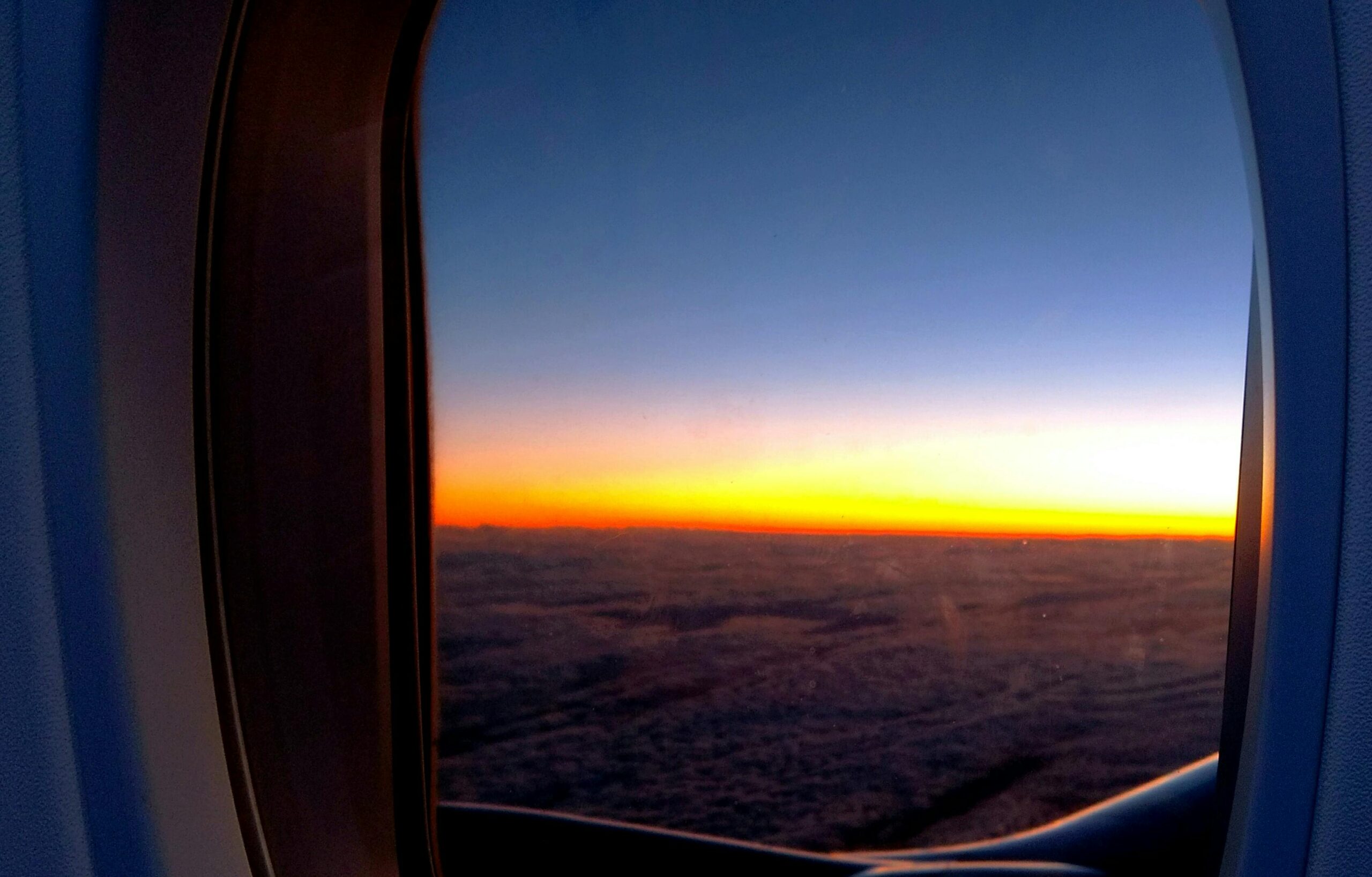 Foto Des Flugzeugfensters Mit Blick Auf Wolken Und Goldene Stunde