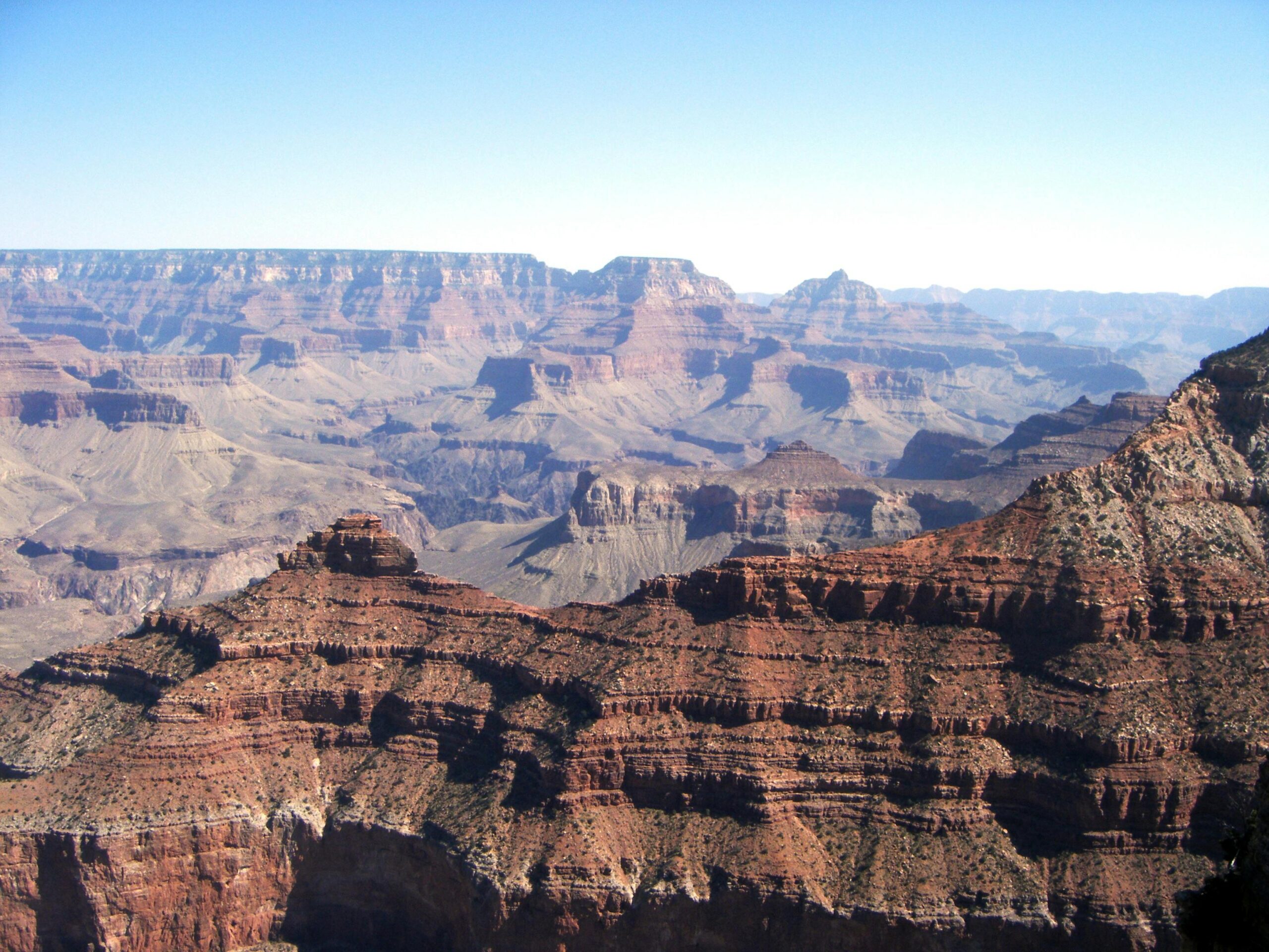 Weitl&Atilde;&curren;ufiger Luftblick auf den atemberaubenden Grand Canyon unter klarem, blauem Himmel.