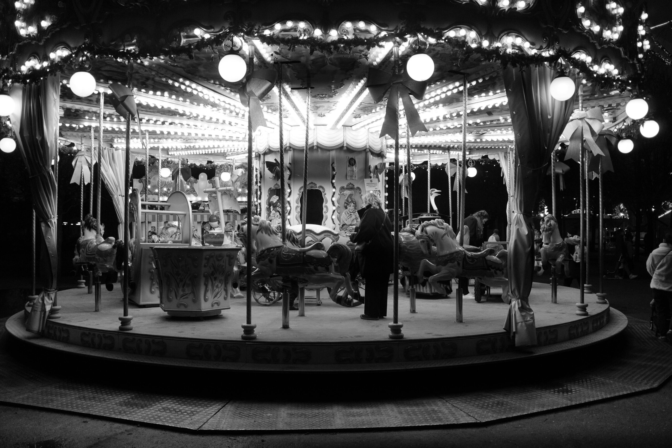 Ein nostalgisches Karussell, das nachts in Schwarzwei&szlig; beleuchtet ist und eine zauberhafte Atmosph&auml;re einf&auml;ngt.